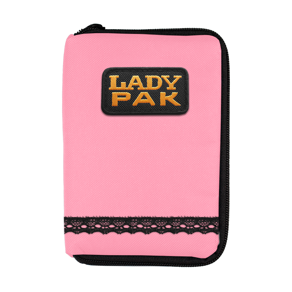 Das Bild zeigt ein pinkes Etui mit einem Reißverschluss und der Aufschrift "LADY PAK" auf einem schwarzen Patch. Am unteren Rand des Etuis befindet sich eine dekorative schwarze Spitzenborte.